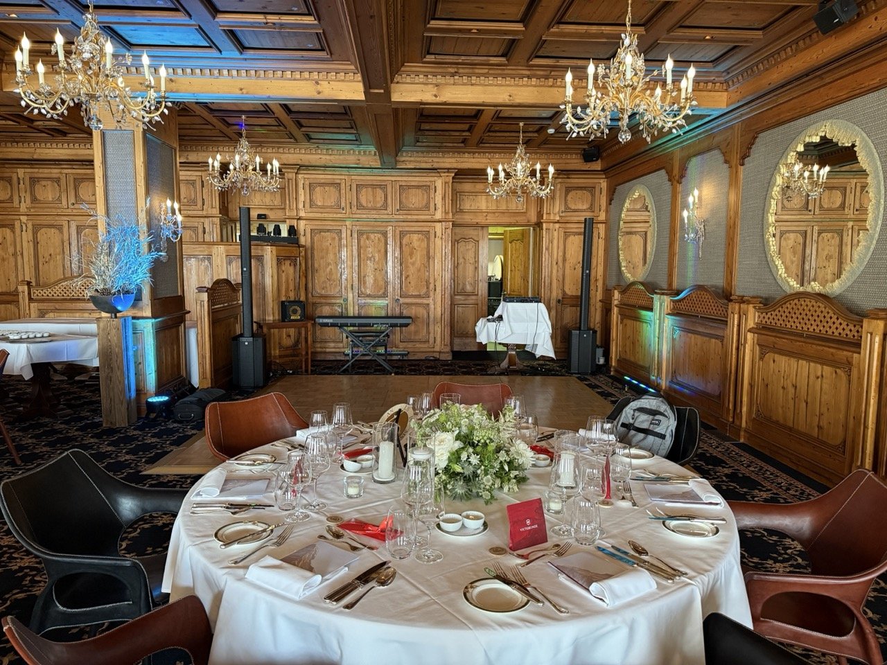 Festlich gedeckter Tisch in einem Holzsaal mit Keyboard, Lautsprechern und dezentem Licht